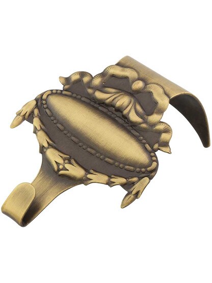 Adams Stamped Brass Picture Rail Hook in Antique Brass.